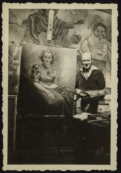 Windhausen poseert in zijn atelier naast een van zijn schilderijen (1938).